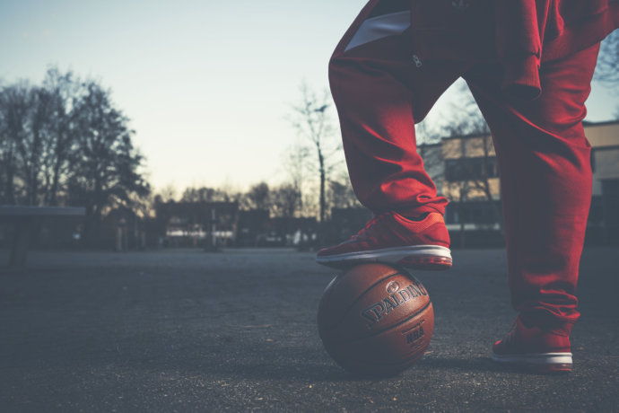 Basketballspieler hält den Fuß auf den Ball © Copyright UK Photographie