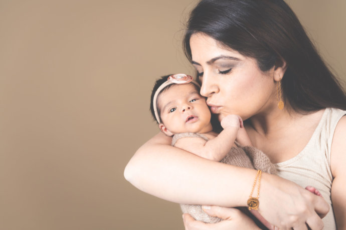 Zusehen ist ein Baby mit der Mama in den Armen © Copyright UK Photographie